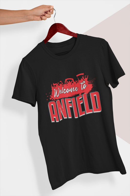 Black tee shirt on a hanger held in a person's hand in front of a white background. Mock-up of a Welcome To Anfield Tee Shirt From Soccer Shocker With a Red and White Design